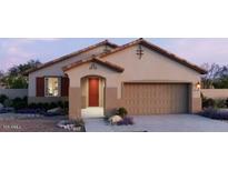 Charming single-story home showcasing a two-car garage, desert landscaping, and a covered entryway at 22631 W Irma Ln, Surprise, AZ 85387