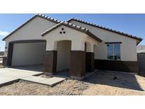 Charming single-story home features a covered entryway and a spacious two-car garage, awaiting personalized landscaping at 22631 W Irma Ln, Surprise, AZ 85387