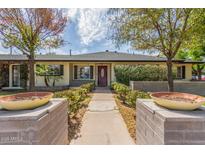 Charming single-story home featuring a manicured front yard with mature trees and a welcoming red front door at 2938 N 18Th Ave, Phoenix, AZ 85015