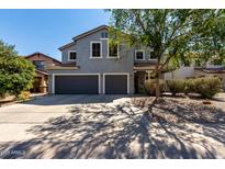 Two-story home with a three-car garage and landscaped front yard at 30165 W Flower St, Buckeye, AZ 85396
