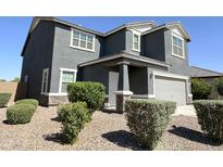 Charming two-story home featuring gray stucco siding, landscaped yard, and an attached two-car garage at 322 S Soledad Ct, Casa Grande, AZ 85194