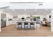 Well-equipped kitchen features white cabinetry, stainless appliances, and a large island with seating at 7223 N 14Th St, Phoenix, AZ 85020