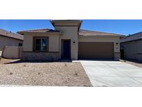 Attractive single-story home with a brown roof, low-maintenance desert landscaping, and an attached two-car garage at 7259 E Blissful Breeze Ln, San Tan Valley, AZ 85143