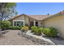 Charming front yard with desert landscaping, stone pathway, and tan exterior at 13593 N 91St Way, Scottsdale, AZ 85260
