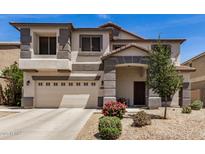 Charming two-story home with neutral stucco, stylish grey accents and a well-manicured, low maintenance front yard at 16386 W Sierra St, Surprise, AZ 85388