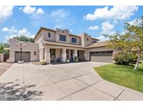 Two-story home featuring a spacious driveway, three-car garage, and charming front porch at 19339 E Mockingbird Dr, Queen Creek, AZ 85142