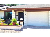 Charming home exterior with a front door, a garage, and decorative landscaping at 2064 S Farnsworth Dr # 38, Mesa, AZ 85209