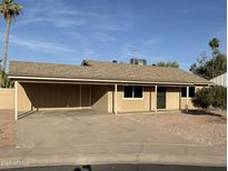 Home exterior featuring a covered parking area, large driveway, and desert landscaping at 2331 W Via Rialto Cir, Mesa, AZ 85202