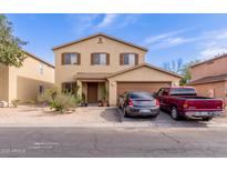 Two-story home with a front-facing two car garage and low maintenance desert landscaping at 2509 E Meadow Land Dr, San Tan Valley, AZ 85140
