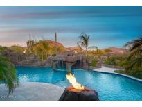 Inviting pool with rock waterfall, fire features, and desert views creating a luxurious outdoor oasis at 26285 N 89Th St, Scottsdale, AZ 85255