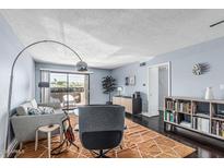 Stylish living room with hardwood floors, light blue walls, a ceiling fan, and sliding glass doors to a patio at 3825 E Camelback Rd # 152, Phoenix, AZ 85018