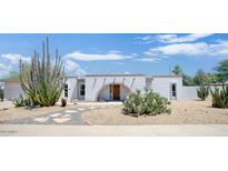 Charming single-story home with unique desert landscaping, featuring cacti and a decorative arched entrance at 4032 E Cannon Dr, Phoenix, AZ 85028