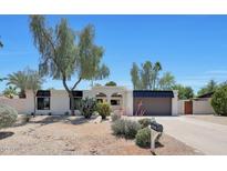 Charming single-story home boasts a well-manicured desert landscape, a spacious driveway, and attached garage at 4079 E Yucca St, Phoenix, AZ 85028