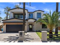 Stunning two-story home featuring a brick exterior, black accents, and lush palm tree landscaping at 4301 E Sells Dr, Phoenix, AZ 85018