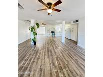 Spacious living room flows into an updated kitchen with new appliances and marble countertops and modern wood-look floors at 4916 W Earll Dr, Phoenix, AZ 85031
