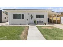 Charming single-story home featuring a well-kept lawn, walkway, covered parking, and decorative front door at 5808 W Myrtle Ave, Glendale, AZ 85301