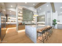 Spacious modern kitchen featuring a large marble island, stainless steel appliances, and stylish pendant lighting at 6126 E Charter Oak Rd, Scottsdale, AZ 85254