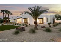 Stunning modern home with a desert landscape, palm trees, and white brick accents create a stylish curb appeal at 7001 E Joan De Arc Ave, Scottsdale, AZ 85254