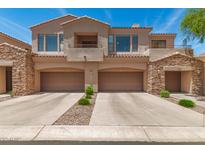 Stylish townhome featuring a two-car garage and stone accents in a well-maintained community at 7445 E Eagle Crest Dr # 1111, Mesa, AZ 85207