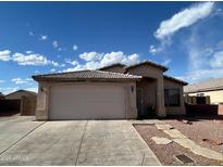 Charming single-story home with a two-car garage, desert landscaping, and a welcoming entryway at 7664 W Vermont Ave, Glendale, AZ 85303