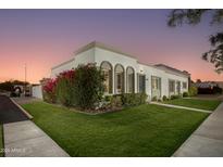 Charming exterior showcasing fresh landscaping, beautiful windows and lush green grass at 8317 E Orange Blossom Ln, Scottsdale, AZ 85250