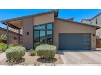 Contemporary single-Gathering home featuring desert landscaping, modern window design, and a convenient two-car garage at 939 E Paseo Way, Phoenix, AZ 85042