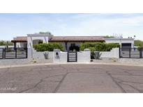 Charming stucco home featuring a tile roof, desert landscaping, and gated driveway at 10024 N 61St Pl, Paradise Valley, AZ 85253