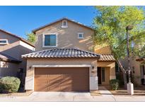 Two-story home featuring a two-car garage, neutral stucco facade, and a meticulously tiled roof at 10225 W Camelback Rd # 45, Phoenix, AZ 85037