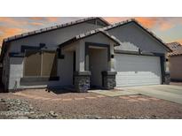Charming single-story home with a two-car garage and low-maintenance desert landscaping at 14728 W Redfield Rd, Surprise, AZ 85379