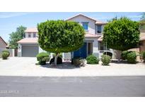 Charming two-story home with landscaped yard and a blue front door at 15148 W Sells Dr, Goodyear, AZ 85395