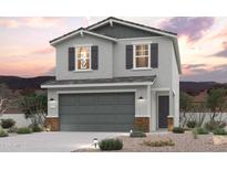 Charming two-story home with gray stucco, dark shutters, and a two-car garage at 17366 W Jessie Ln, Surprise, AZ 85387