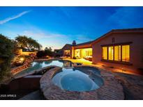 Inviting backyard pool and spa with beautiful landscaping and a seamless transition to indoor living at 17975 W Willow Dr, Goodyear, AZ 85338