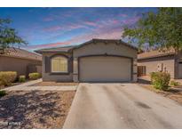 Inviting single-story home featuring a two-car garage and low-maintenance desert landscaping at 20251 W Madison St, Buckeye, AZ 85326