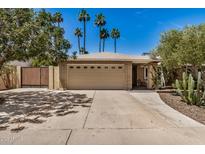Tan brick home with two-car garage, desert landscaping, and palm trees in front at 2256 S Las Flores --, Mesa, AZ 85202