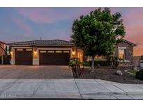 Charming home with a three-car garage, stone accents, and a well-manicured front yard at 2741 E Odessa St, Mesa, AZ 85213