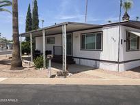 Charming single-story home featuring a covered porch, landscaped yard, and mature trees at 4065 E University Dr # 155, Mesa, AZ 85205
