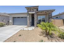Charming single-story home with stone accents, low-maintenance landscaping, and a convenient two-car garage at 40848 W Hillman Dr, Maricopa, AZ 85138