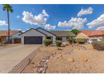 Well-maintained single-story home with desert landscaping, a brick-lined driveway, and a black garage door at 4340 E Nisbet Rd, Phoenix, AZ 85032