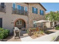 Charming townhouse featuring stone accents, a cozy patio, and a balcony for enjoying the outdoors at 4772 E Portola Valley Dr # 102, Gilbert, AZ 85297