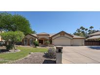 Inviting single-story home featuring a well-manicured lawn and a spacious three-car garage at 5521 W Northwood Dr, Glendale, AZ 85310