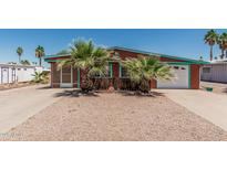 Charming home featuring a low maintenance yard, white garage door and palm tree landscaping at 7326 E Juanita Ave, Mesa, AZ 85209