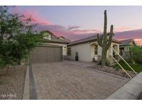 Charming single-Gathering home featuring desert landscaping, brick driveway, and a two-car garage at 8055 E Jaeger St, Mesa, AZ 85207