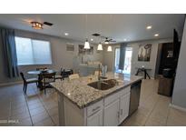 Modern kitchen boasts a large island with granite countertops, stainless steel appliances, and an open concept layout at 8419 S 40Th Dr, Laveen, AZ 85339