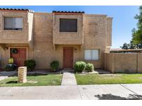 Charming townhome featuring a stucco facade, front lawn, and a welcoming front entrance at 948 S Alma School Rd # 97, Mesa, AZ 85210