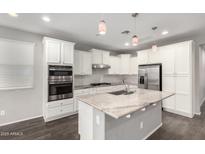 Bright kitchen features stainless steel appliances, granite countertops, white cabinets, and a center island with a sink at 10059 E Tamery Ave, Mesa, AZ 85212