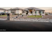 Beautiful single-story home featuring stone accents, lush landscaping, and a well-manicured lawn at 18125 W Montebello Ct # 67, Litchfield Park, AZ 85340