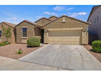 Charming single-story home showcasing a two-car garage and desert landscaping for low maintenance appeal at 21582 W Cocopah St, Buckeye, AZ 85326