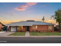 Charming brick home featuring a well-manicured lawn and stylish landscaping, showcasing curb appeal at 2225 E Monterosa St, Phoenix, AZ 85016