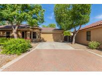 Charming single-story home featuring desert landscaping, mature trees, and a two-car garage at 2424 E Peach Tree Dr, Chandler, AZ 85249