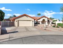 Charming single-story home featuring a terra cotta roof, a two-car garage and meticulously landscaped front yard at 322 E Gary Cir, Mesa, AZ 85201